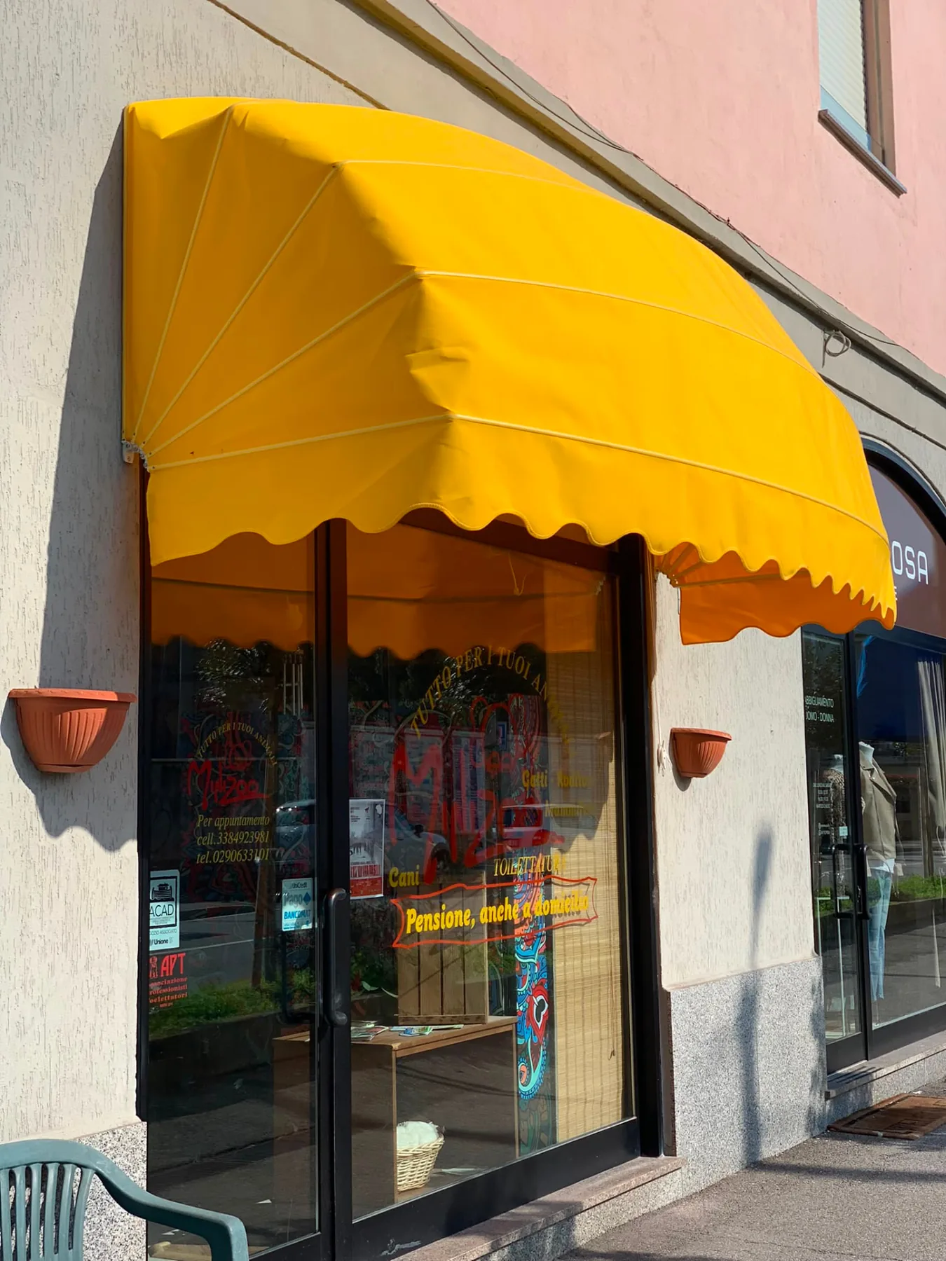 Tenda a cappottina gialla installata sulla vetrina di un negozio