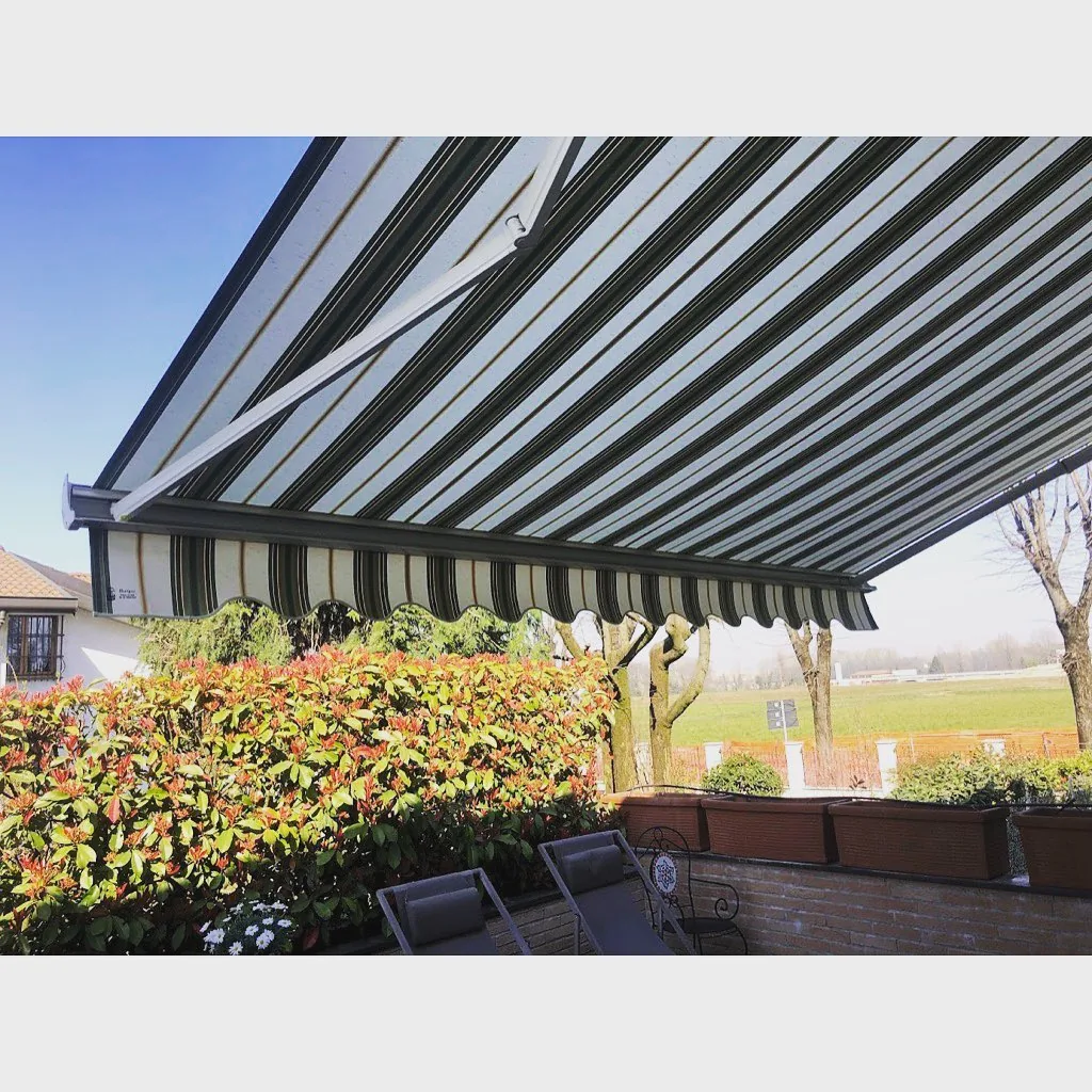 Tenda da sole a bracci aperta su terrazzo affacciato sul giardino