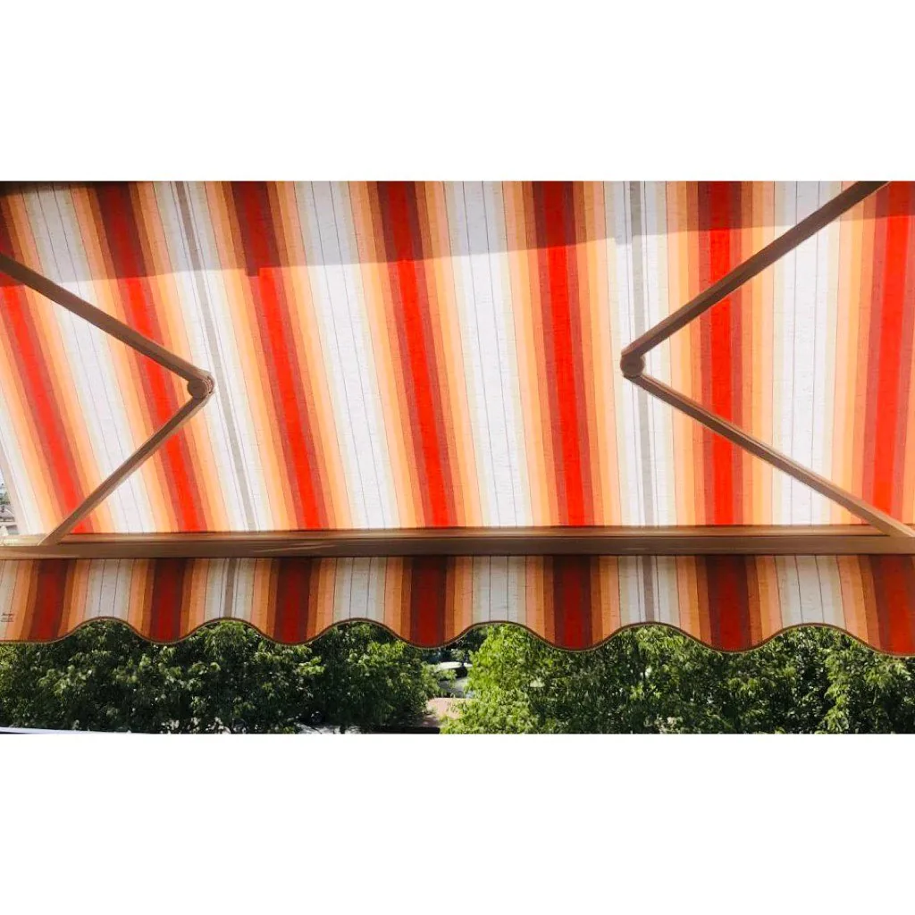 Tenda da sole a bracci con mantovana sagomata sopra il giardino