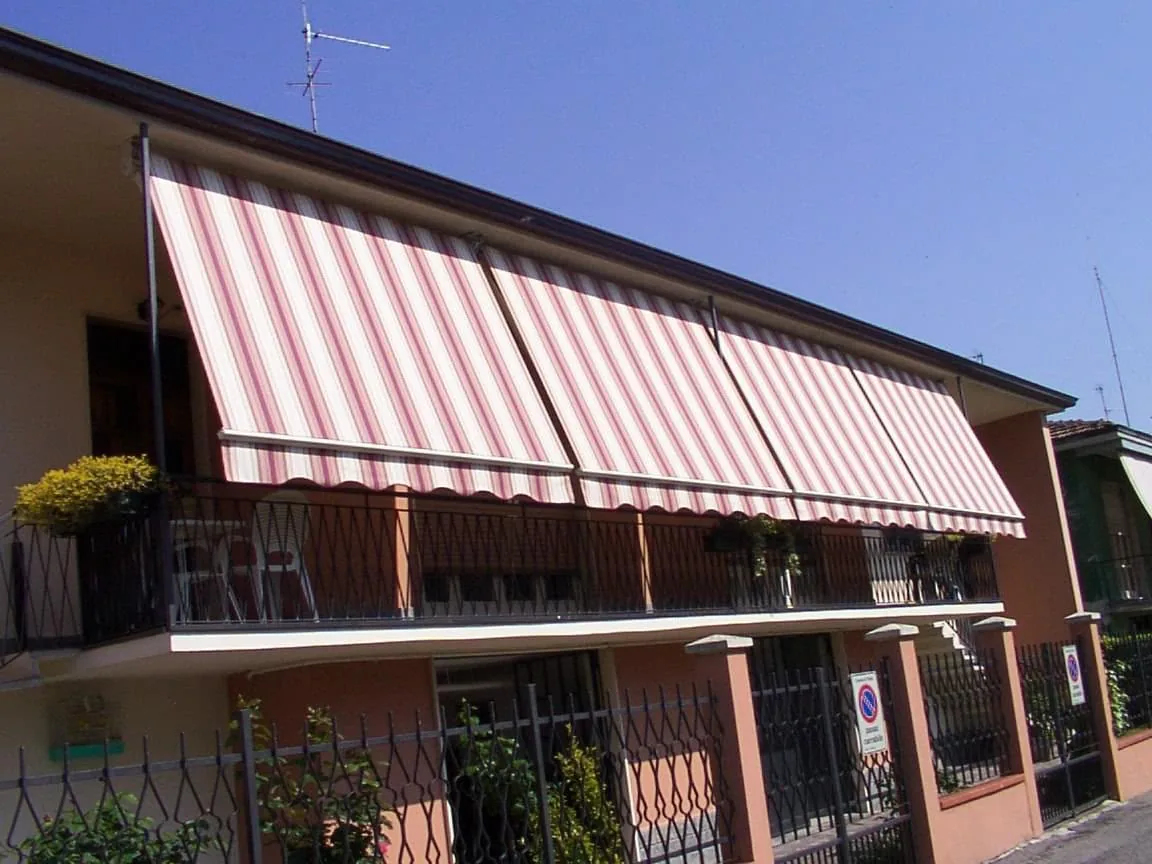 Tenda da sole a caduta a righe rosa su balcone di abitazione