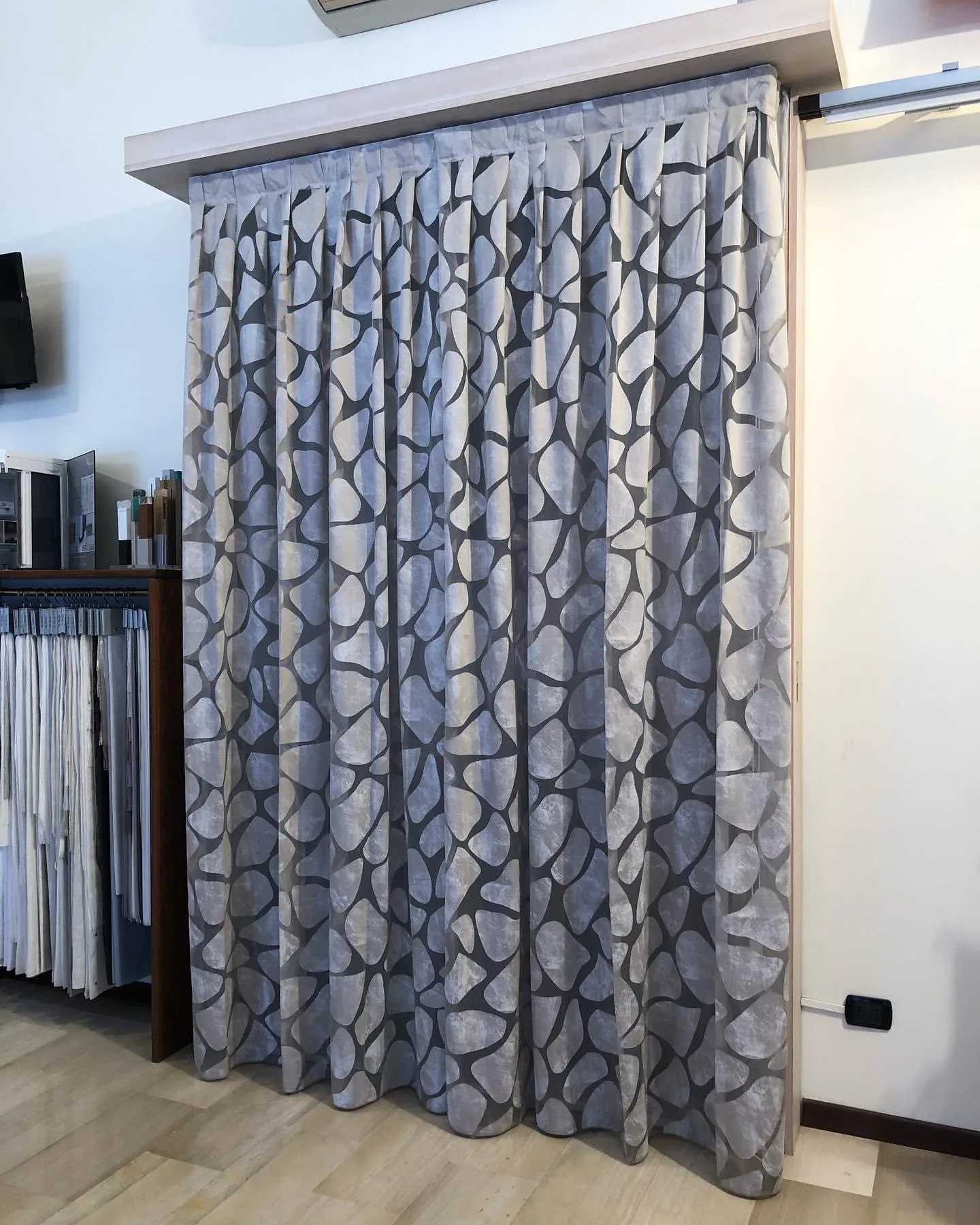 Tenda da interno a pieghe con tessuto fantasia esposta in showroom