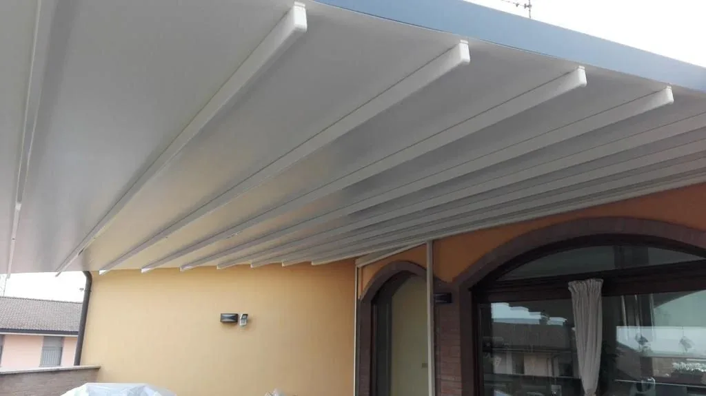 Pergola con copertura tessile bianca a impacchettamento su terrazzo