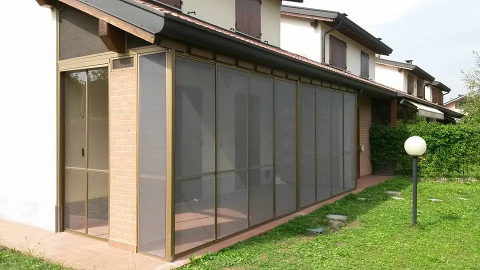 Veranda chiusa con zanzariere scorrevoli a telaio in alluminio bronzo
